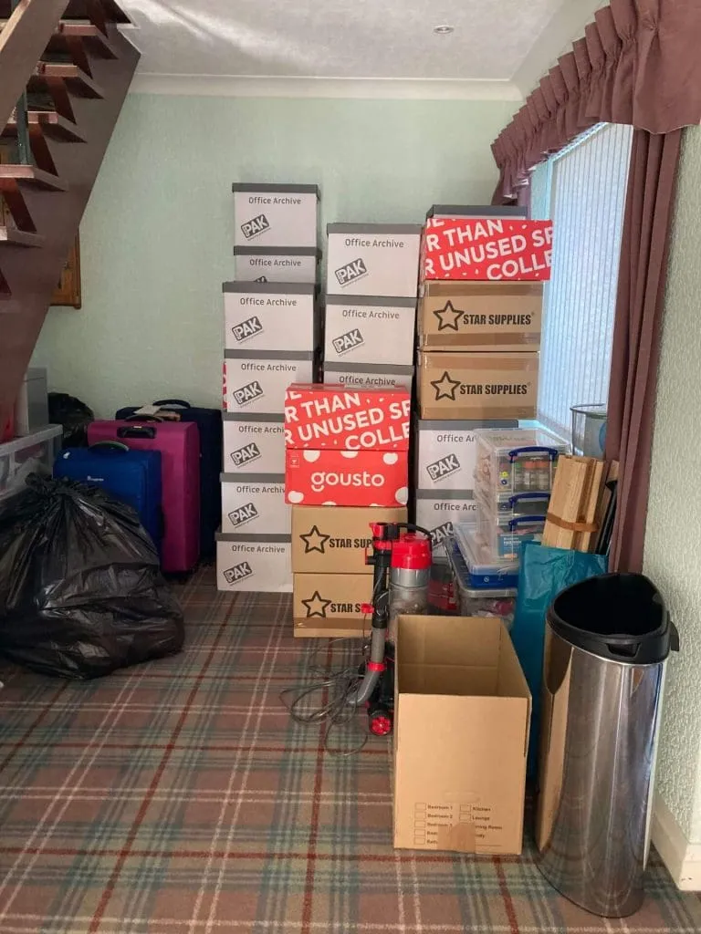 hall filled with boxes, staircase to the left